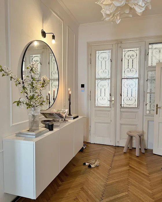 European Apartment Entryway with White Cabinet and Oval Mirror