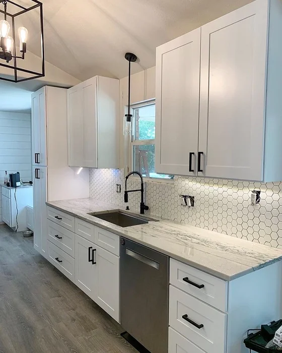 White Farmhouse Kitchen with Hexagon Backsplash and Vaulted Ceiling