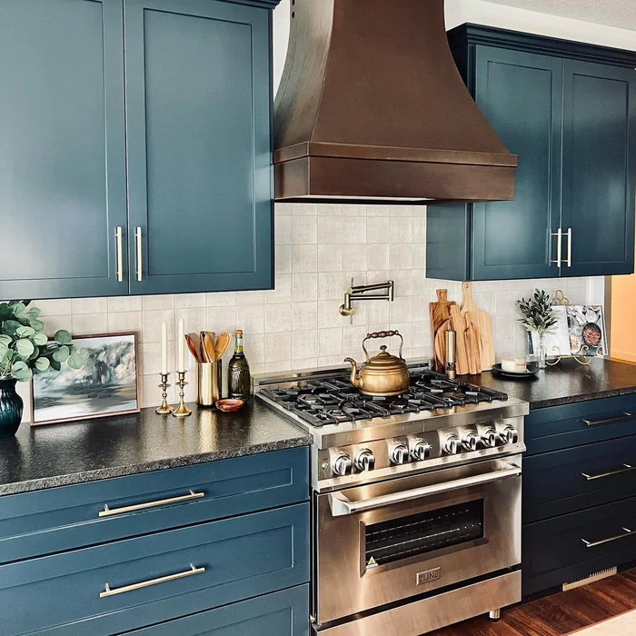 Teal Kitchen with Copper Range Hood and Dark Countertops