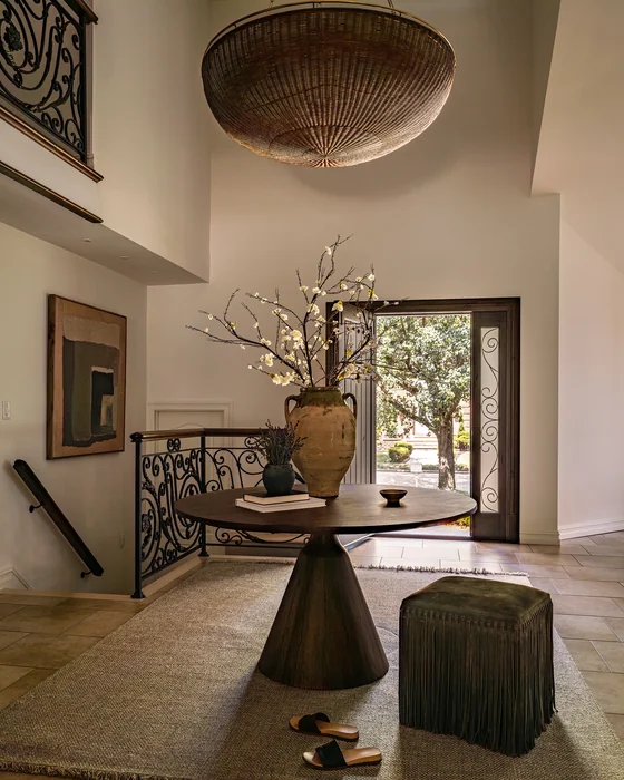 Luxury Grand Foyer with Round Dark Table and Wicker Dome Chandelier