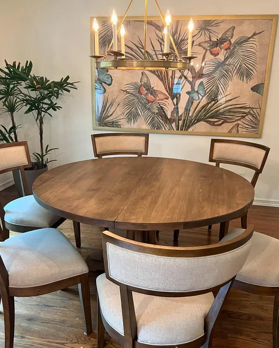 Round Walnut Dining Table with Upholstered Chairs and Brass Chandelier