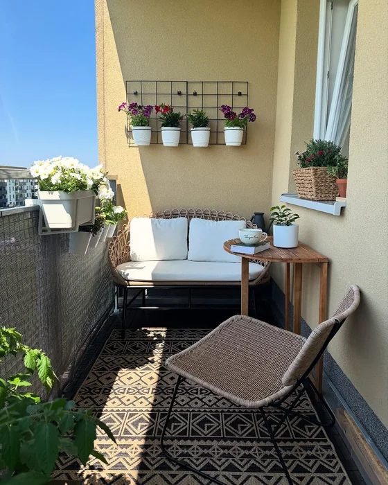 Clean Small Balcony with Rattan Sofa and Wall Flower Grid